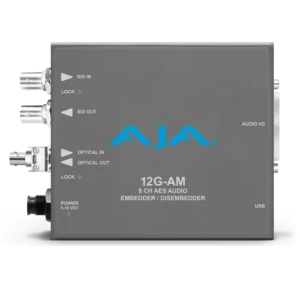 Procesador de audio profesional compacto AJA 12G-AM-R-ST en color gris, con logotipo azul de la marca y conectores metálicos circulares de fibra óptica tipo ST junto a puertos BNC para vídeo digital.