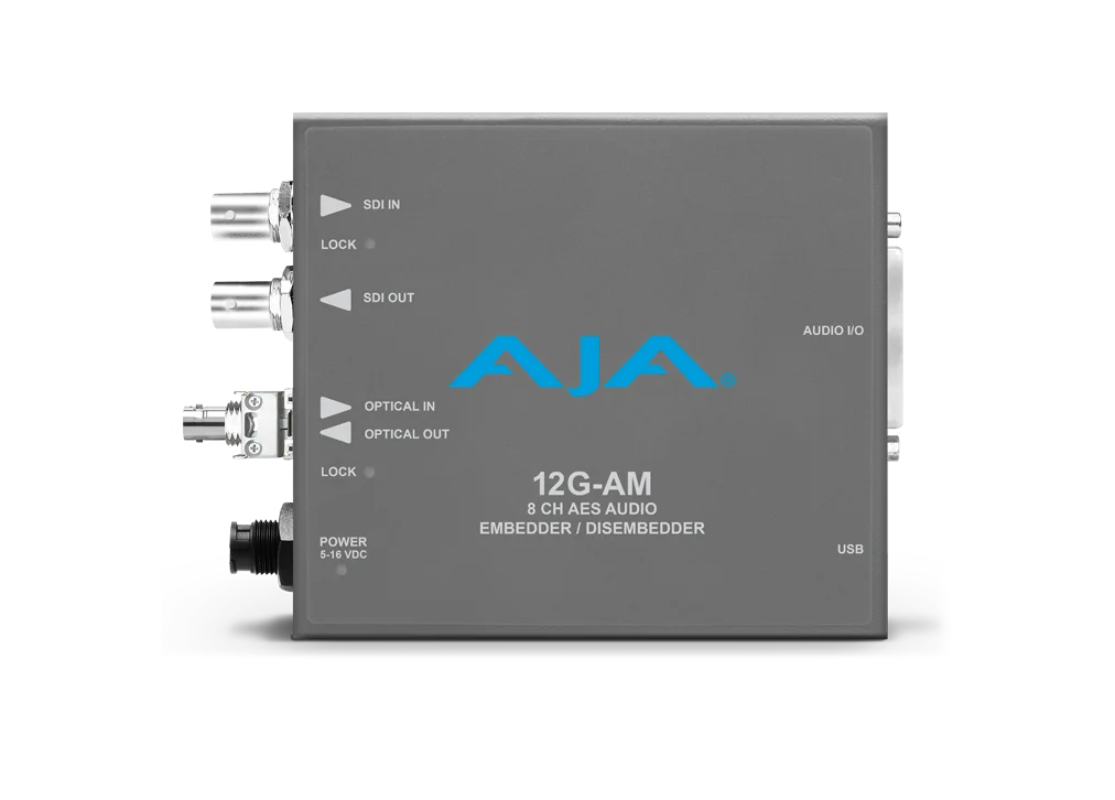 Procesador de audio profesional compacto AJA 12G-AM-R-ST en color gris, con logotipo azul de la marca y conectores metálicos circulares de fibra óptica tipo ST junto a puertos BNC para vídeo digital.