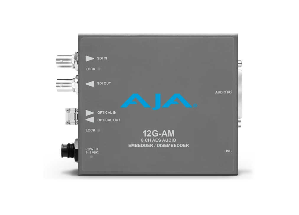 Procesador de audio profesional AJA 12G-AM-R visto de frente, mostrando sus conectores SDI, entradas de fibra óptica tipo LC y el puerto de audio digital de alta densidad sobre una carcasa metálica gris.
