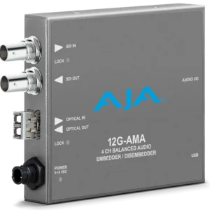 Procesador de audio profesional AJA 12G-AMA-T en chasis metálico gris, mostrando el transmisor de fibra óptica tipo LC, los conectores BNC de entrada y salida de vídeo y el puerto de alimentación.